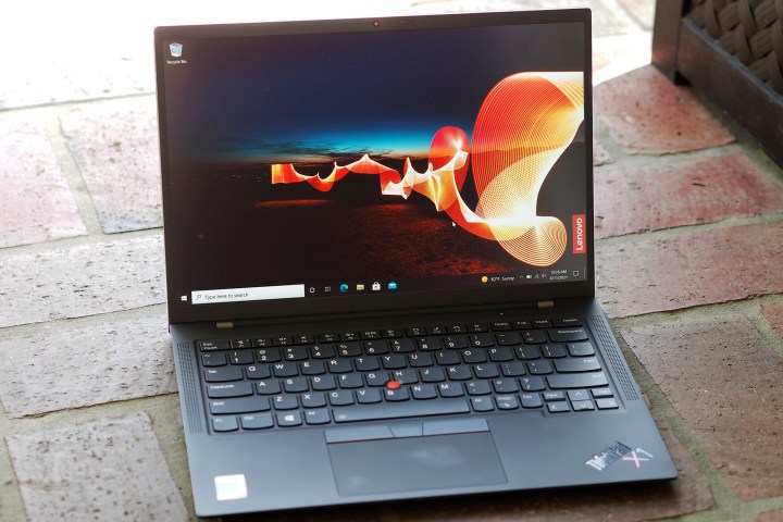 A view of the opened ThinkPad X1 Carbon Gen 9 sitting on a brick surface.