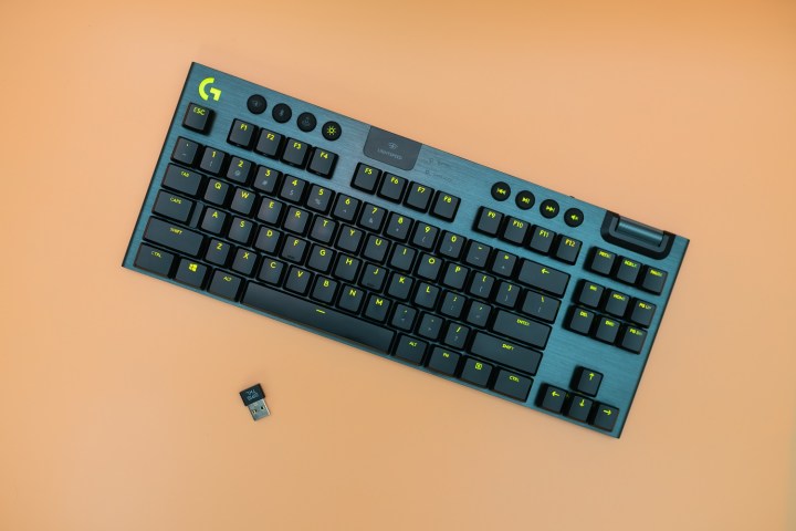 Logitech G915 TKL keyboard on an orange background.