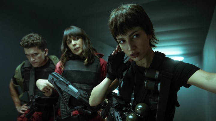 Три человека с оружием и броней незаметно приближаются к зданию в сцене пятого сезона «Ограбления денег».