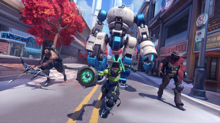 A team of Overwatch characters advance down a street in Overwatch 2.