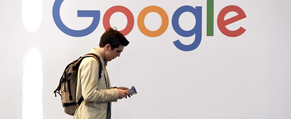 A man walks past the logo of the US multinational technology company Google during the VivaTech trade fair.