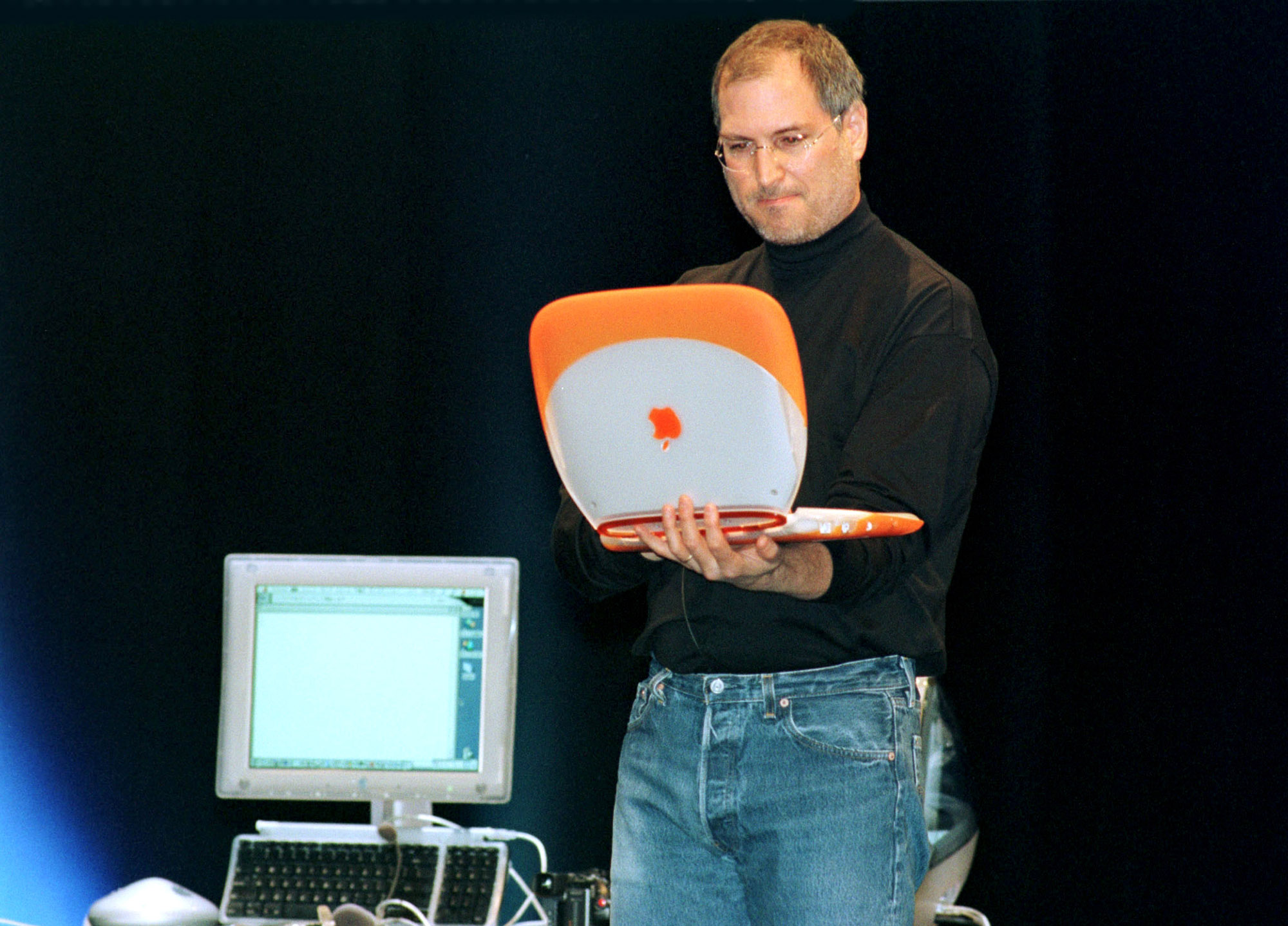 Steve Jobs at holding an orange iBook Macworld Expo In Tokyo, Japan On February 16, 2000.
