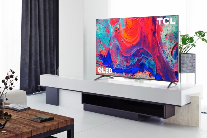 TCL 5-й серии 4K QLED Google TV установлен на развлекательном центре в гостиной.