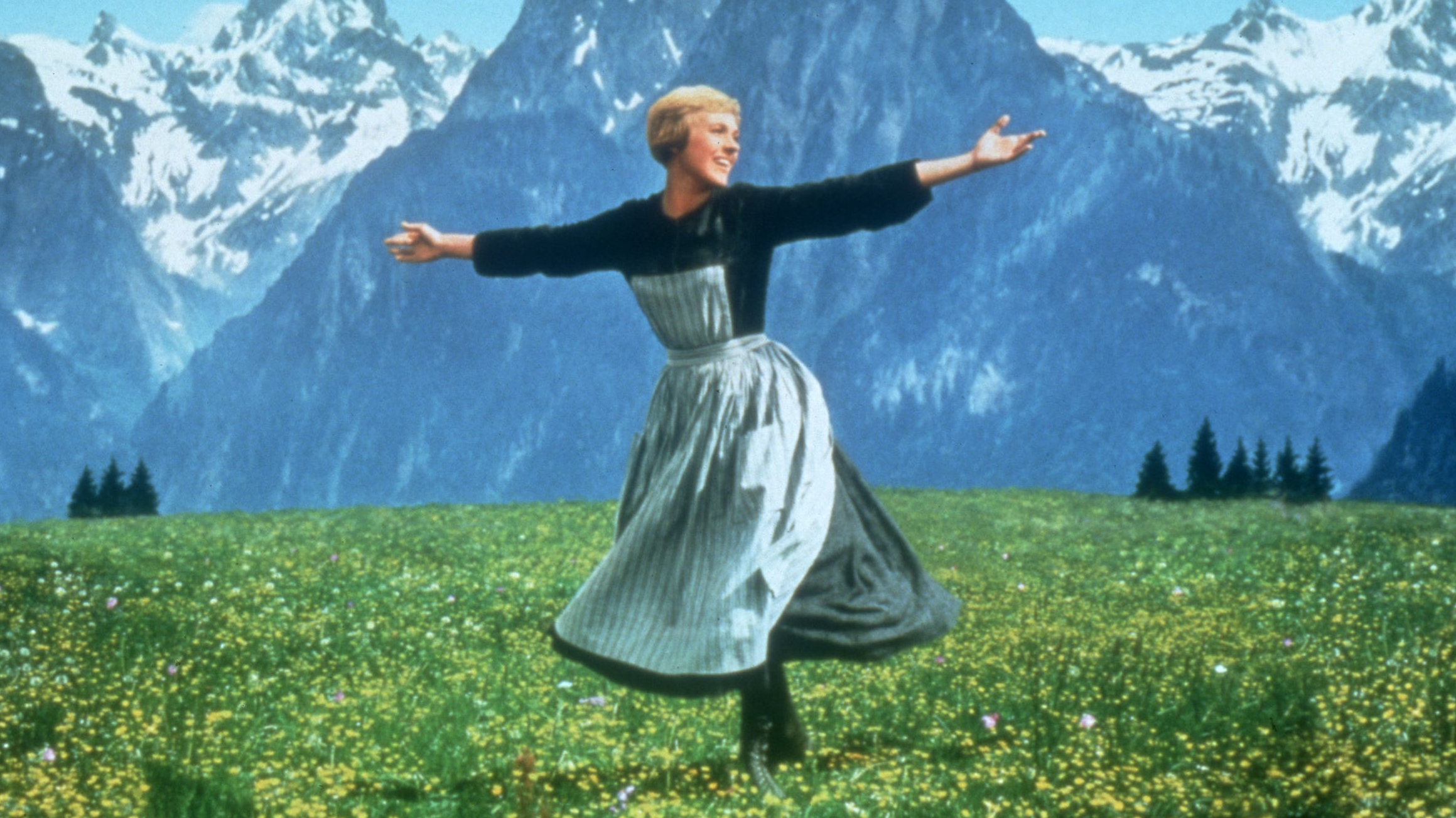 Julie Andrews como María extendiendo sus brazos en los Alpes en Sonrisas y lágrimas.