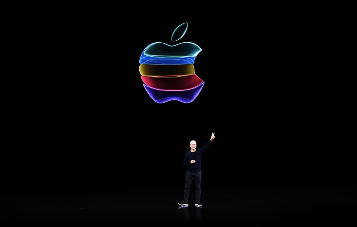 Tim Cook em frente ao logotipo colorido da Apple.
