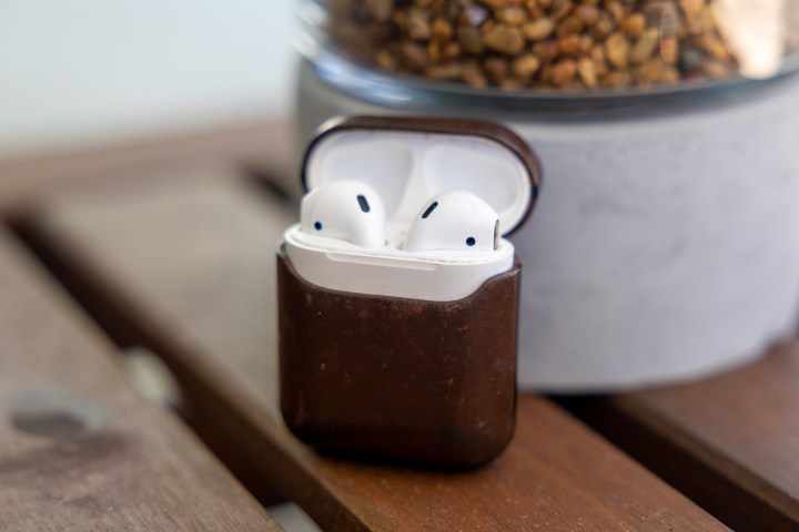 Apple AirPods in a Nomad leather case.