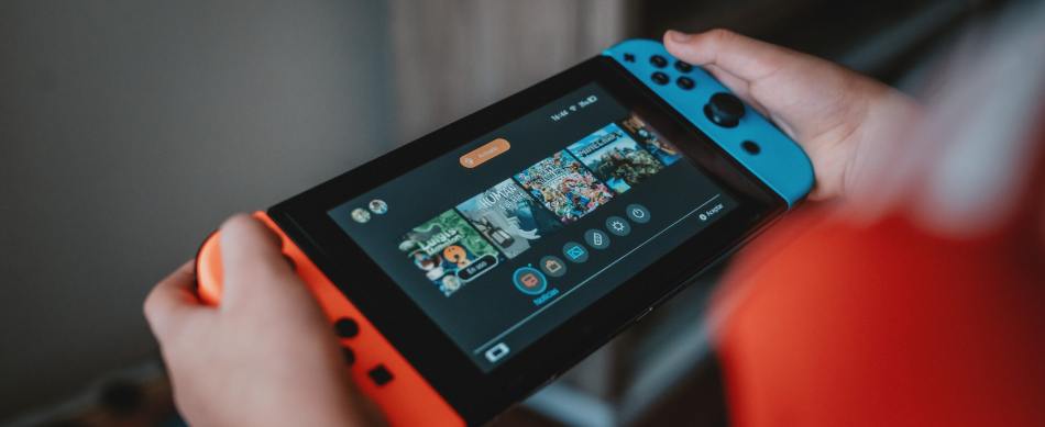 Person holding Nintendo Switch, looking at the home screen.