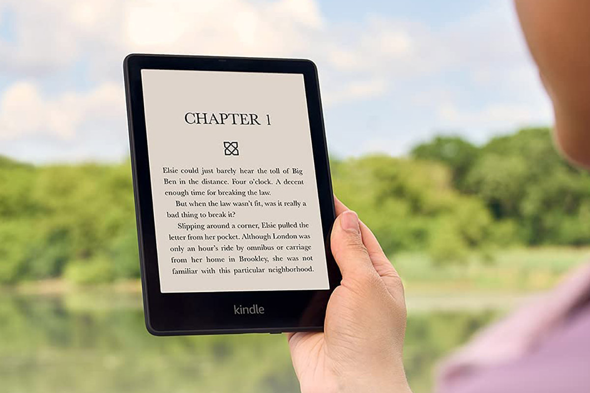 Uma pessoa lê em um Amazon Kindle Paperwhite ao ar livre.