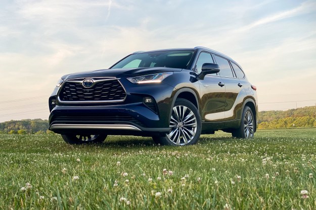 Angled front view of the 2021 Toyota Highlander Hybrid Platinum in a field (driver's side).
