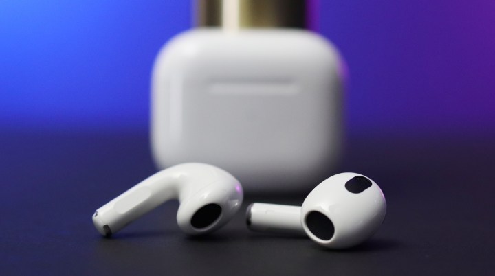 AirPods 3 on a surface with a case in the background.