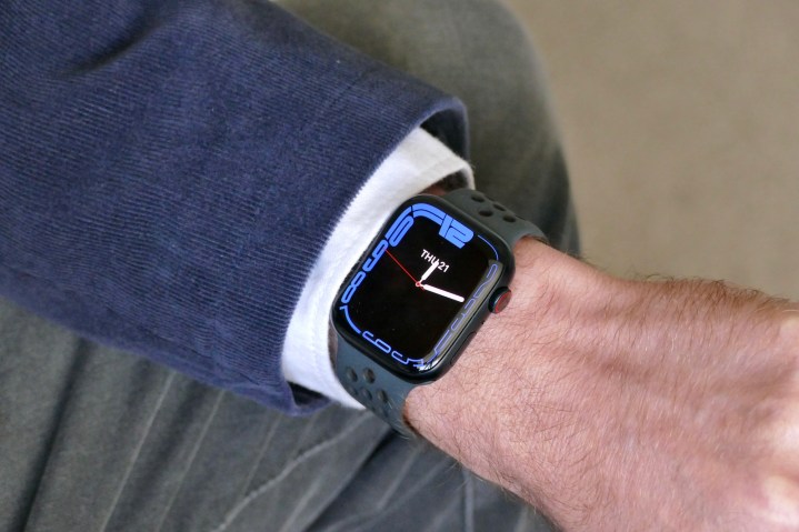 Apple Watch Series 7 al polso di una persona mostra la sua faccia sagomata.