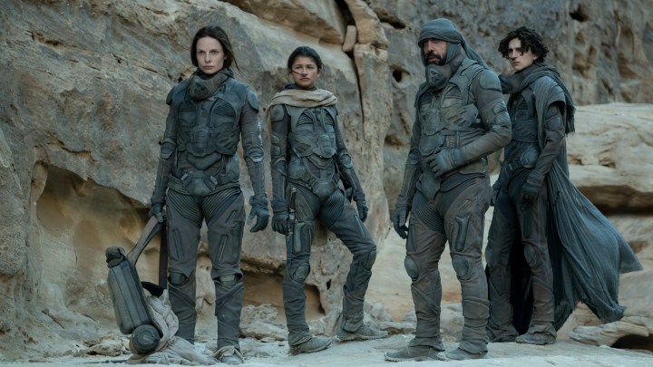 The cast of Dune stands in the desert of Arrakis in a scene from the movie.