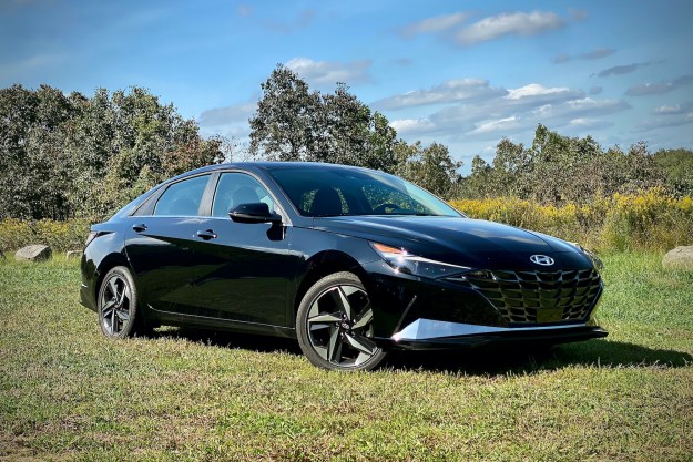 Angled front view of the 2021 Hyundai Elantra Hybrid Platinum in a grassy field (passnger's side).