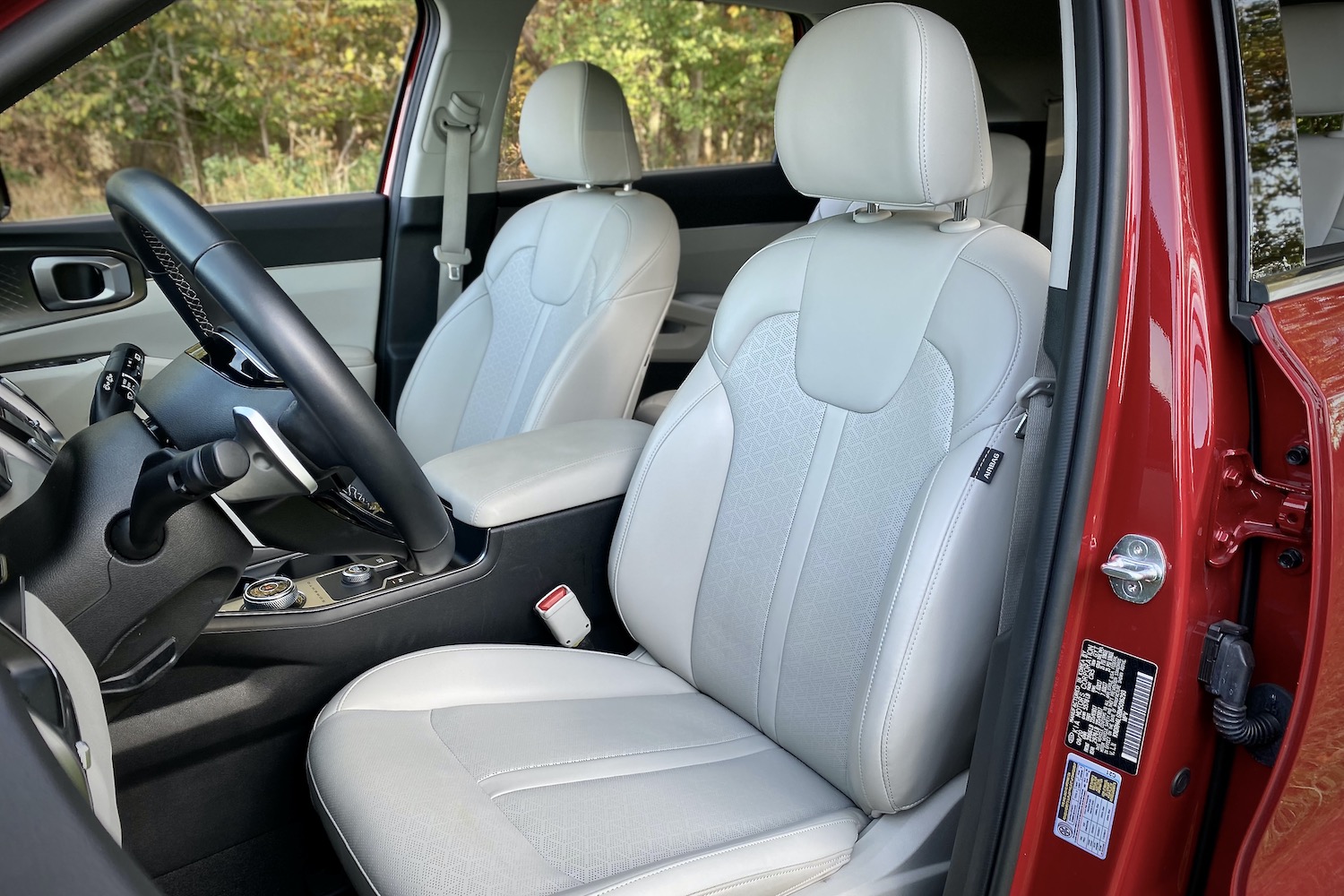 Driver's seat in the 2021 Kia Sorento Hybrid with trees in the background.
