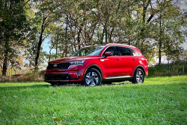 Front driver's side from an angle of the 2021 Kia Sorento Hybrid in a grassy field.