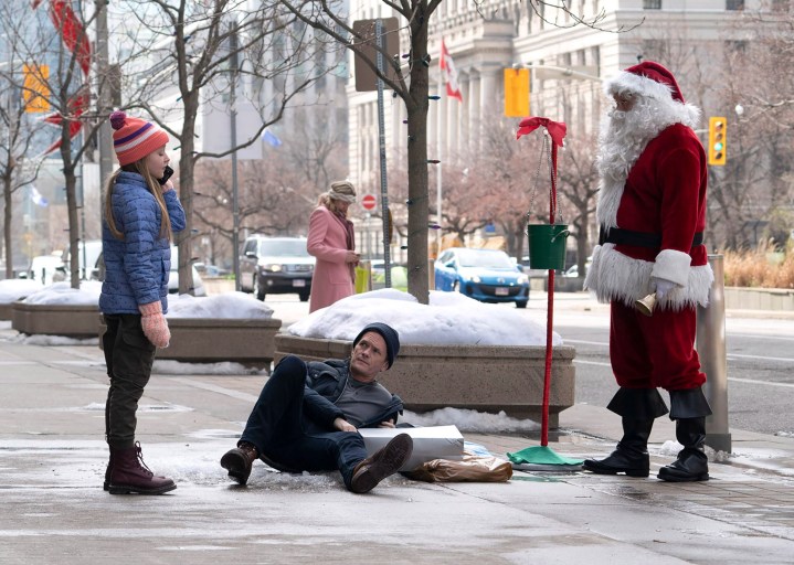 Neil Patrick Harris falls on ice near a Santa Claus in a scene from 8-Bit Christmas.