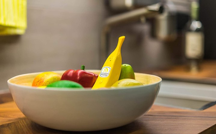 The banana phone sits in a bowl of fruit.