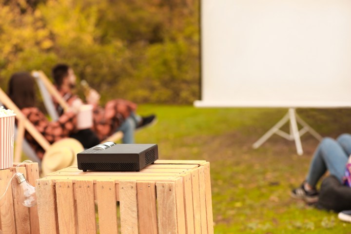 An outdoor projector set up on a small table.