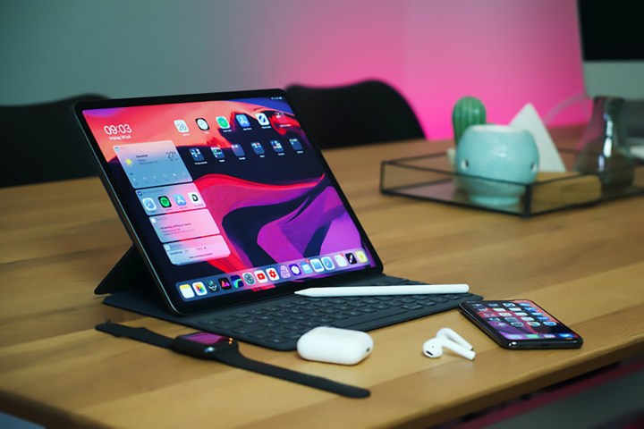 iPad Pro em uma mesa com AirPods e um iPhone nas proximidades.