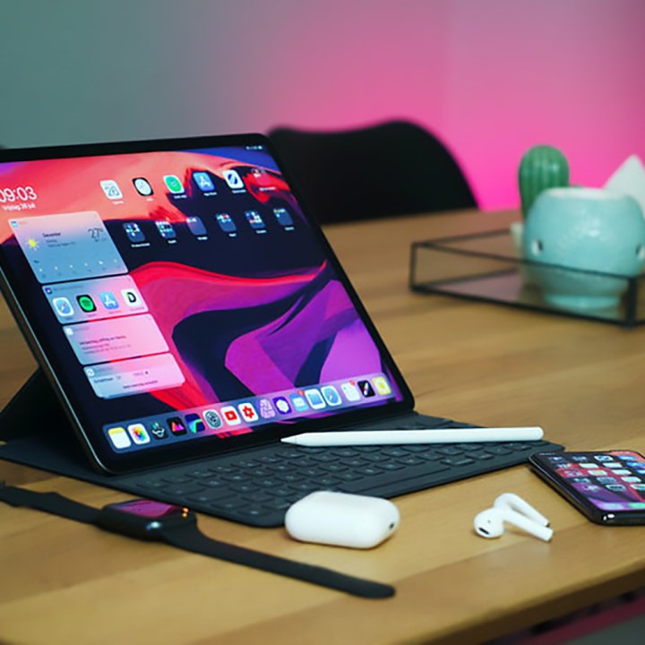 iPad Pro 12-9 اینچی در یک قاب روی یک میز با AirPods، Apple Watch و iPhone در نزدیکی آن قرار گرفته است. 