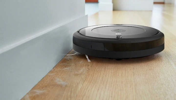 An iRobot Roomba 694 next to a wall, vacuuming pet hair.