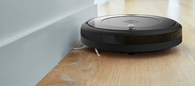 An iRobot Roomba 694 next to a wall, vacuuming pet hair.