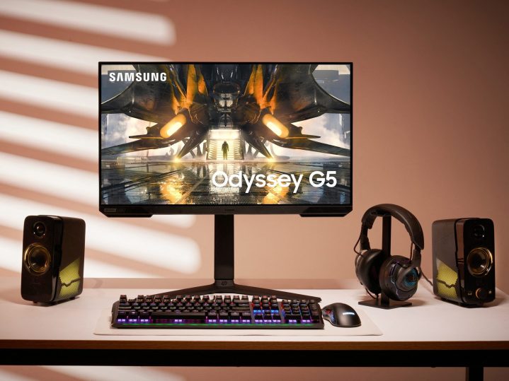 The Samsung Odyssey G5 32-inch curved 144Hz monitor sits on a desk next to computer accessories.