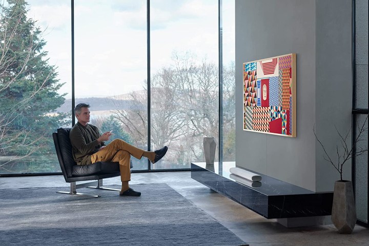 A man sits in front of a 55-inch Samsung The Frame TV in the living room.