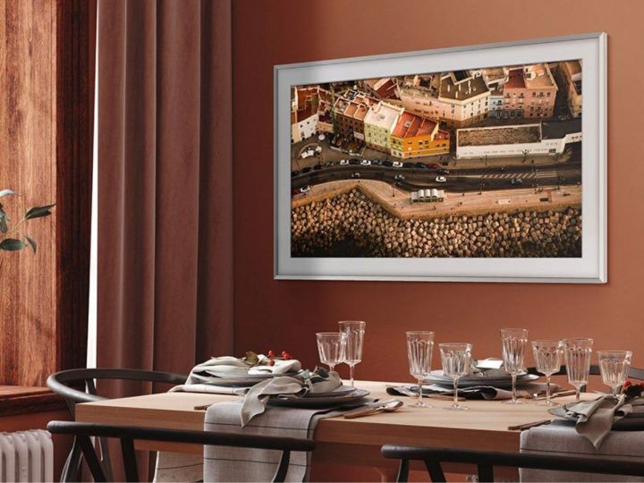 A 55-inch Samsung The Frame 4K TV hangs on a wall in a dining room.