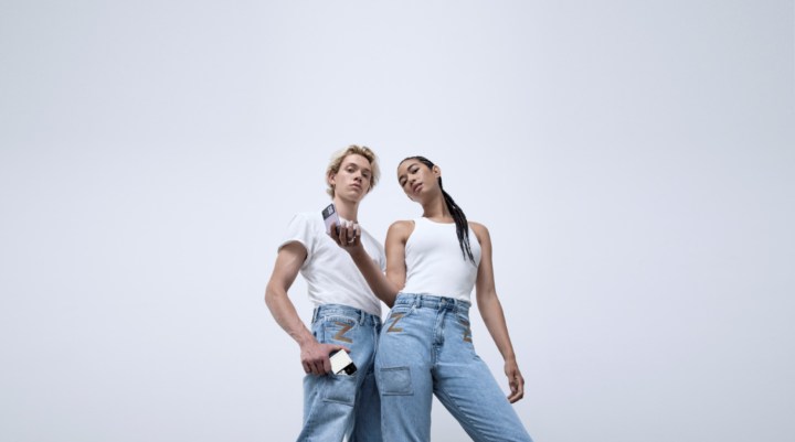 Two people hold a Galaxy Z Fliup 3 which wearing jeans designed for the phone.