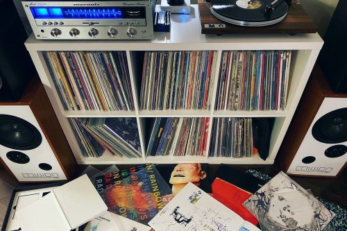 A vinyl collection shelf with receiver and turntable.