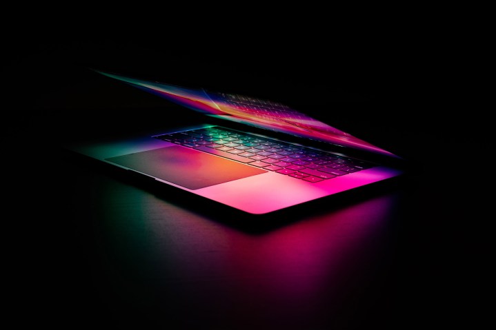 Một chiếc Macbook Pro nằm trong bóng tối, được chiếu sáng bởi chính màn hình của nó.