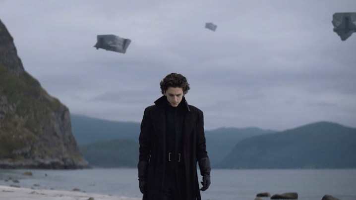 Paul camina con la cabeza gacha cerca de un lago en la película Dune de 2021.