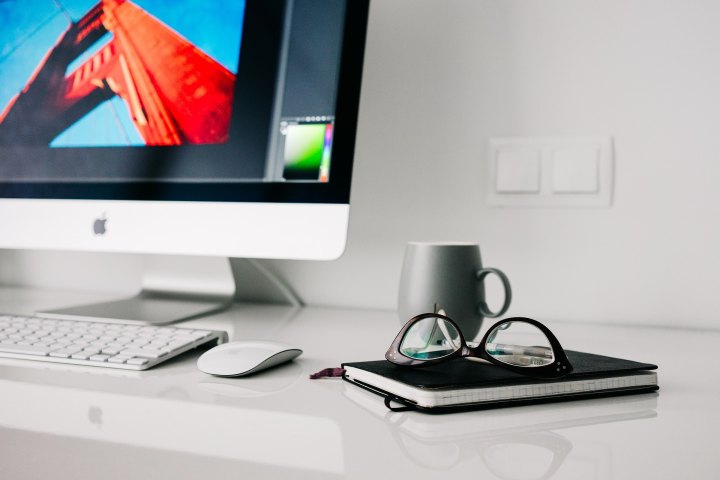 iMac on a desk with glasses and a notebook from Pixabay.
