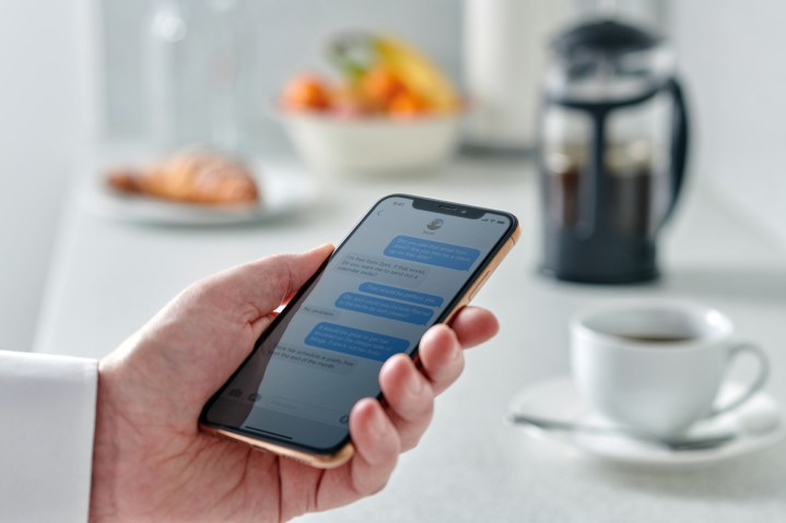 Close-up of a man iMessaging on an iPhone.