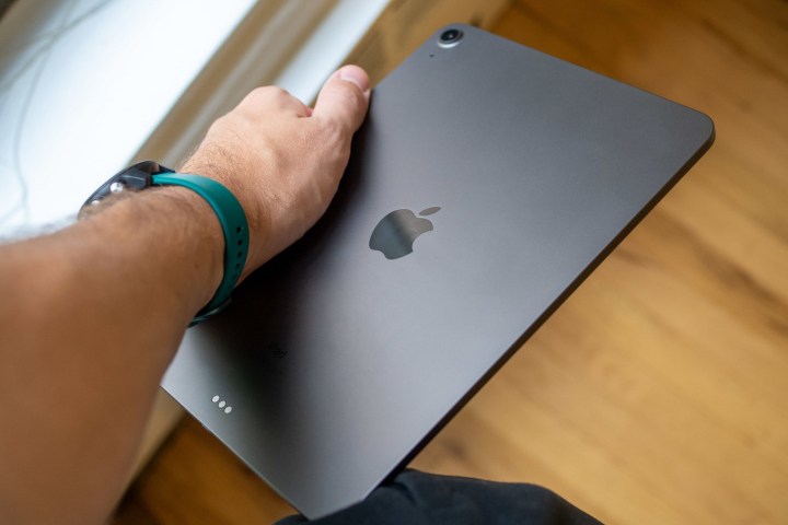 The arm of a person holding an Apple iPad Air 2020.
