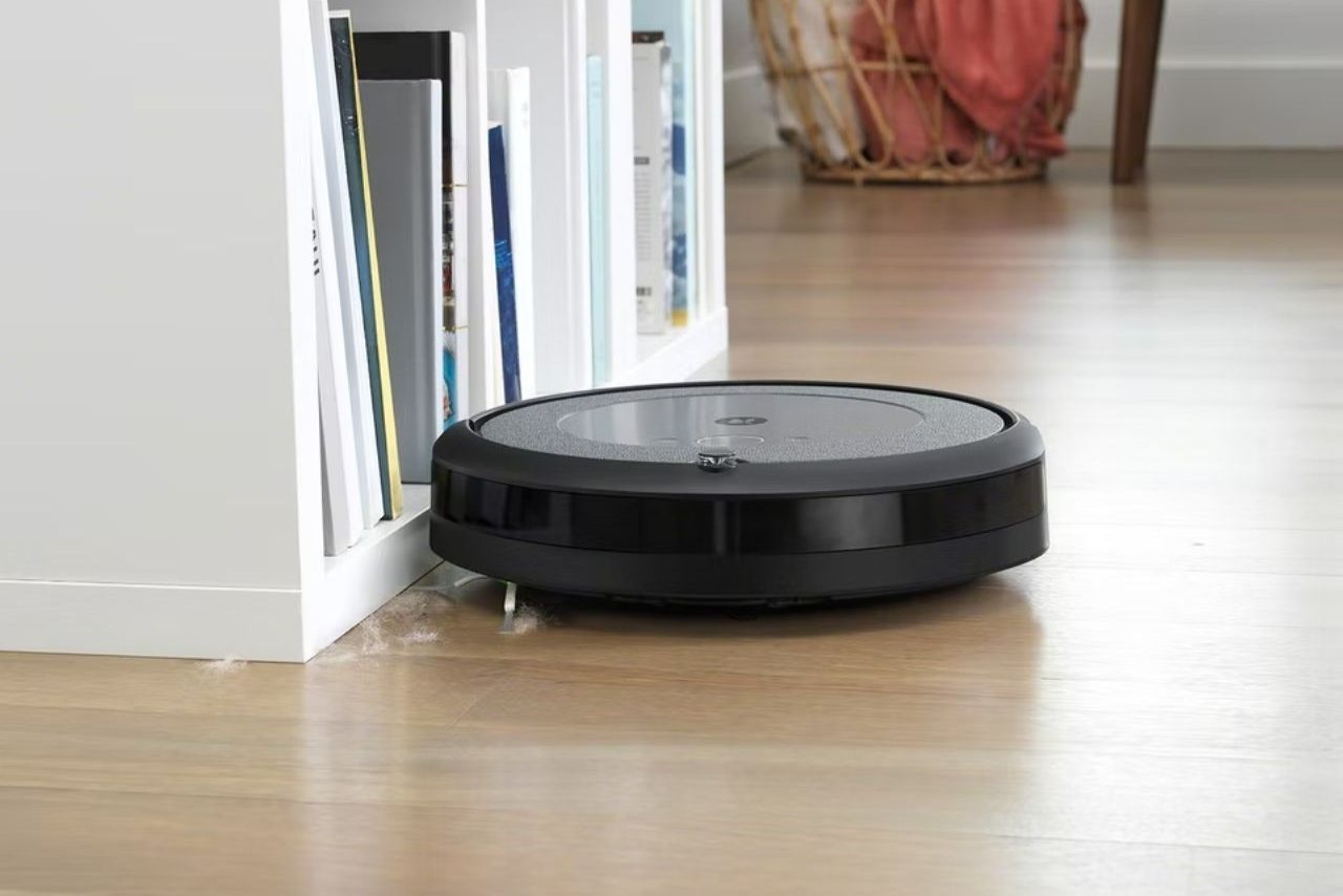 iRobot Roomba i3 Plus limpando um piso de madeira.