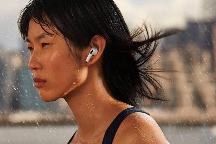 Woman wearing a pair of Apple AirPods 3 in the rain.