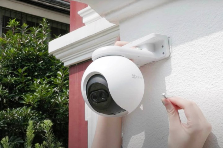 A EZVIZ C8PF being hung up outside a home.