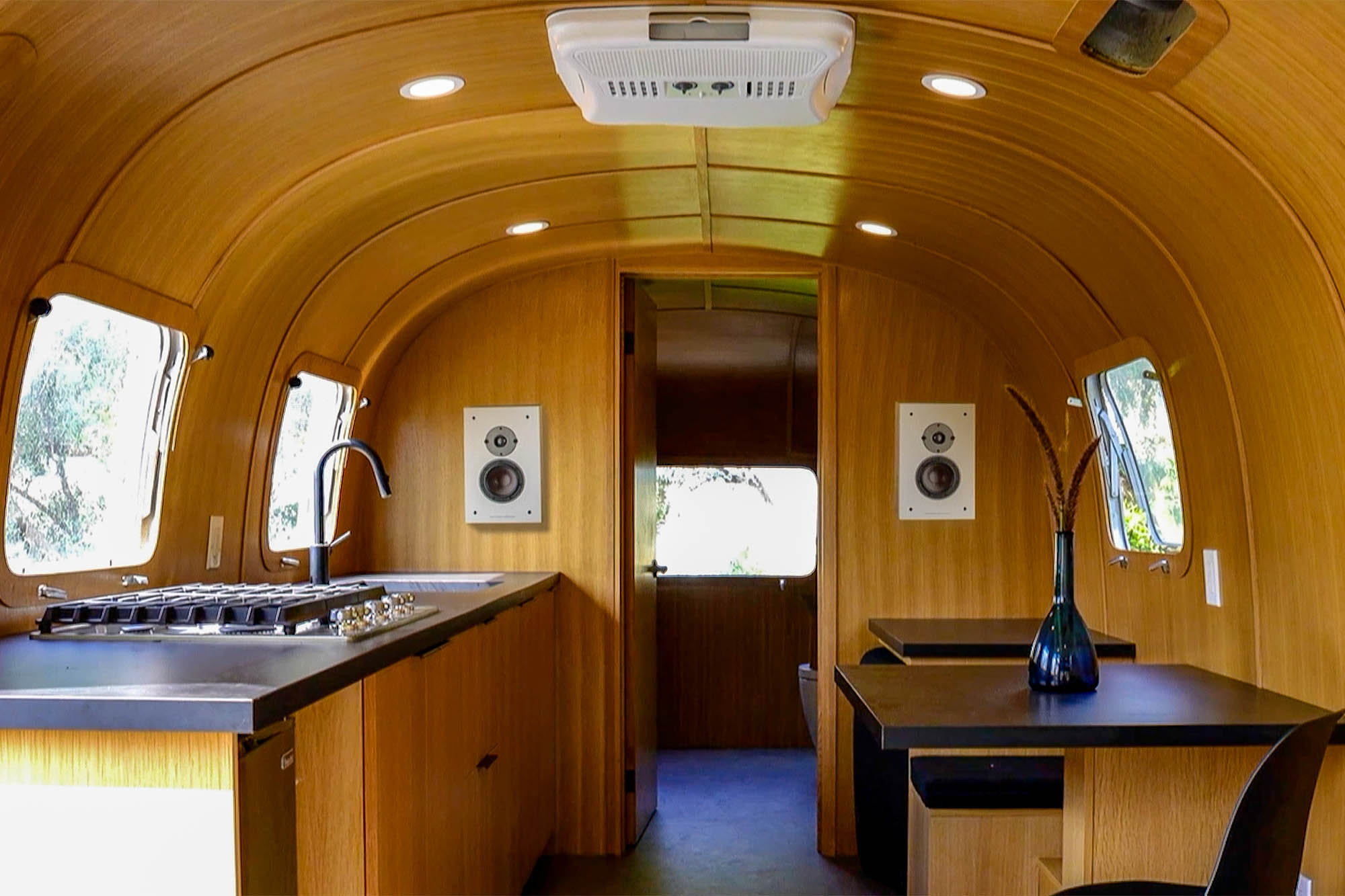 The interior of an Airstream. Walls lined with wood panels.