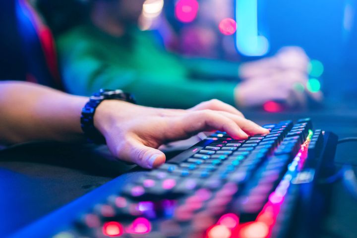 A closeup of gamer using a mechanical keyboard with rgb lighting
