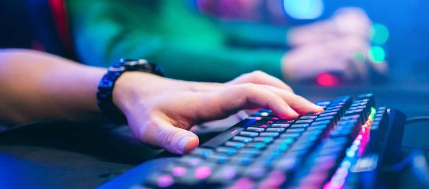 A closeup of gamer using a mechanical keyboard with rgb lighting