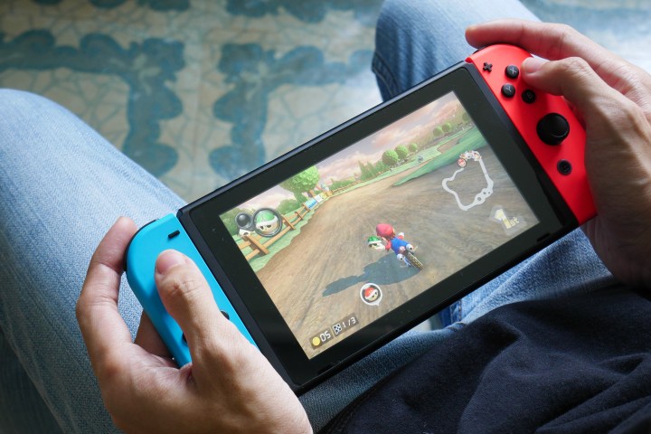 Uma pessoa joga Mario Kart 8 Deluxe em um Nintendo Switch no modo portátil.