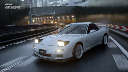 A Mazda Rx 7 drifts in the rain on a Tokyo Expressway in Gran Turismo 7.