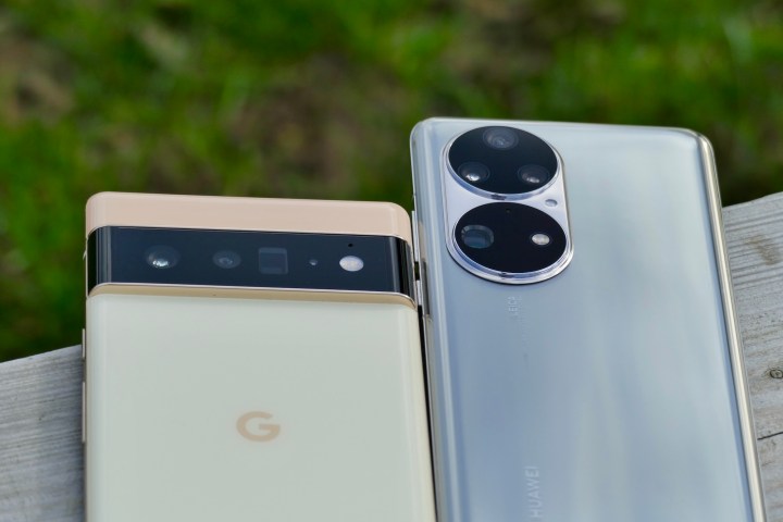 The Huawei P50 Pro and Pixel 6 Pro sit on a plank with their camera modules visible.