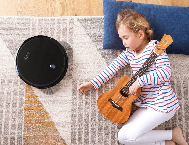Little girl sleeping on a rug while eufy by Anker BoostIQ RoboVac 11S (Slim) Robot Vacuum Cleaner vacuums.