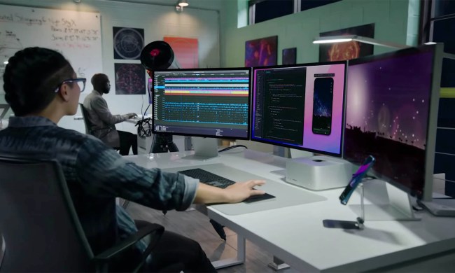 A person works at a station equipped with the all new Mac Studio and Studio Display.