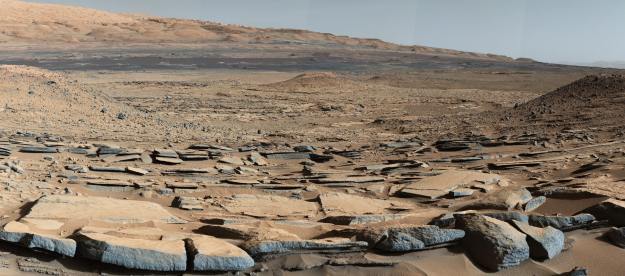 A view from the "Kimberley" formation on Mars taken by NASA's Curiosity rover. The strata in the foreground dip towards the base of Mount Sharp, indicating flow of water toward a basin that existed before the larger bulk of the mountain formed.