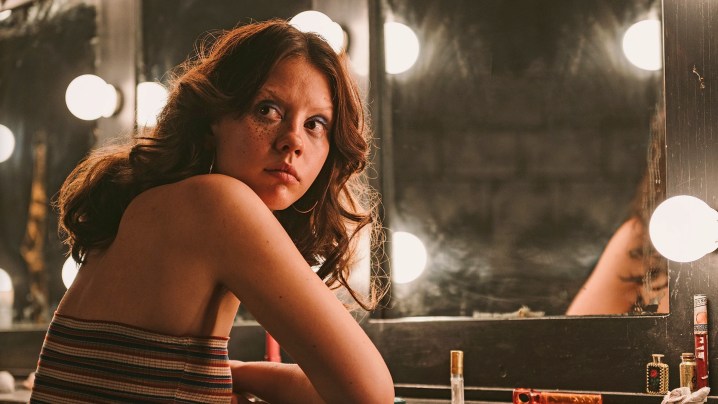 Mia Goth sits in front of a mirror in X.