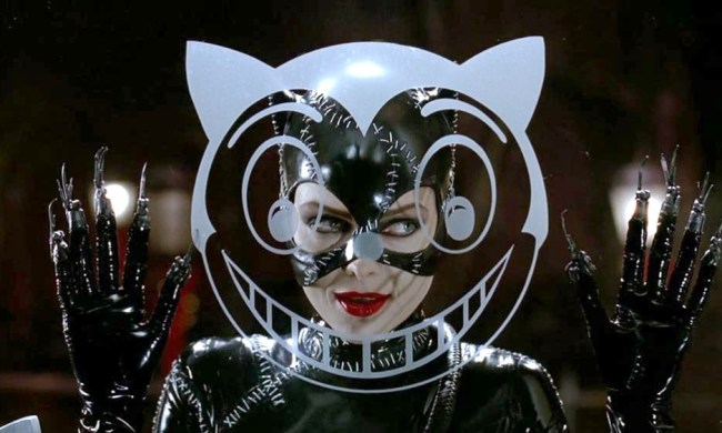A smiling Catwoman peers through a glass window in Batman Returns.